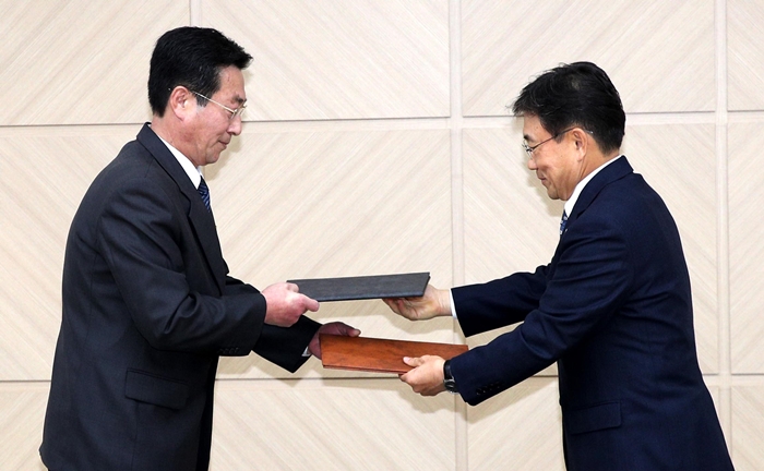 권덕철 보건복지부 차관(오른쪽)과 박명수 북한 보건성 국가위생검열원장이 지난 7일 개성 남북공동연락사무소에서 열린 남북 보건의료협력 분과회담을 마친 뒤 공동보도문을 교환하고 있다. 사진공동취재단